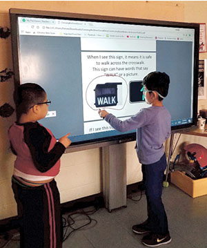 Two male Forum students working together at Clear Touch interactive computer panel