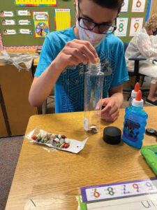 Masked student working on project during in-school instruction at The Forum School