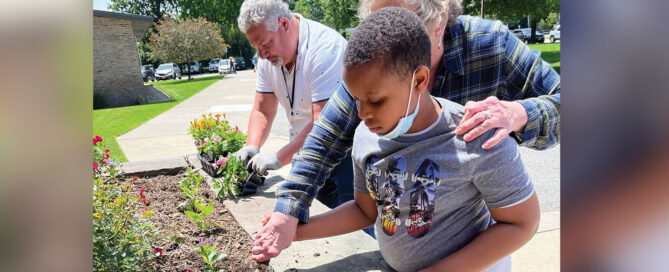 Forum student working outdoors in a raised garden